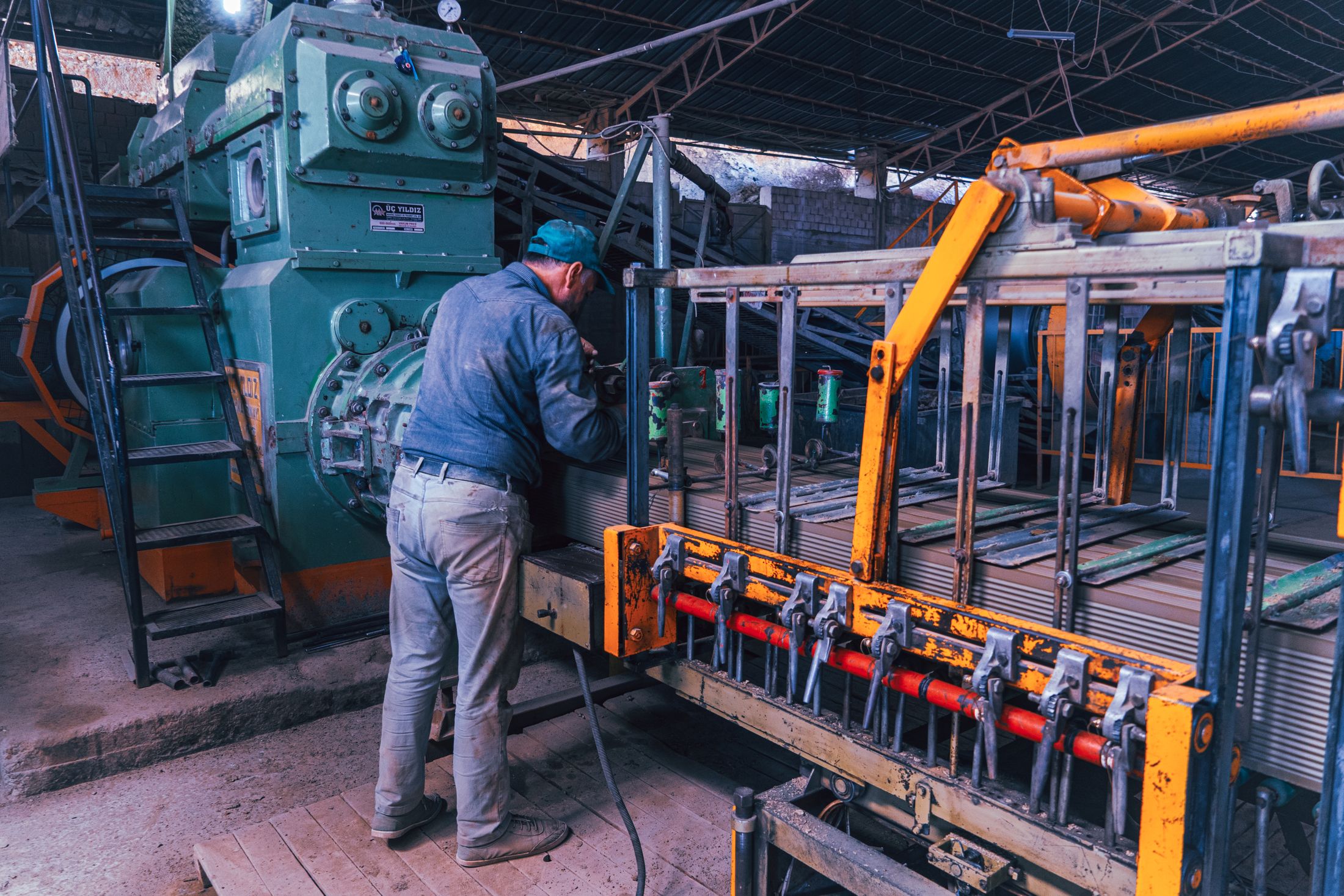 A worker concentrating on skilled work in a metal workshop